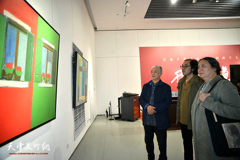 孙建平、郑岱、郑金岩在画展现场观看作品。