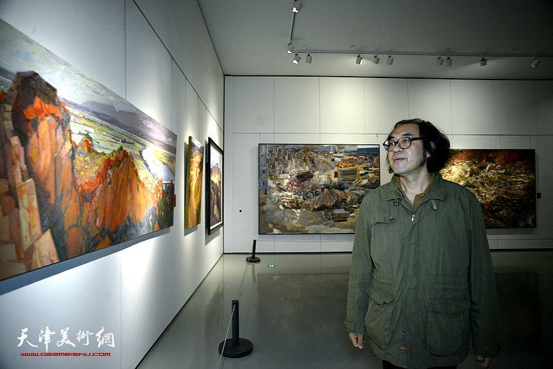 郑金岩在画展现场观看作品。
